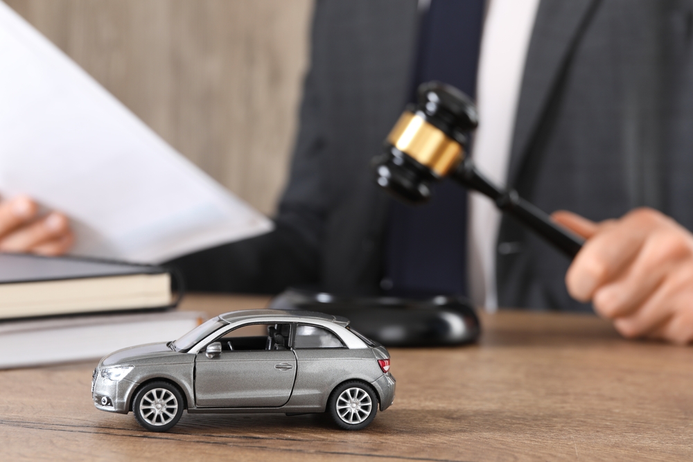 Attorney stamping a contract during an initial car accident consultation while the client prepares key questions.