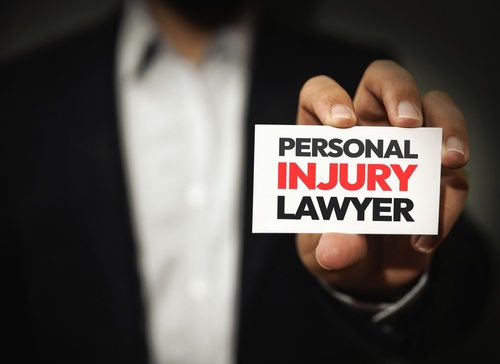 Hand holding a business card that reads ‘Personal Injury Lawyer’