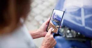 A Lady Taking Picture Of Damaged Car On Mobile Phone