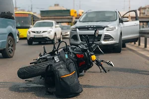 The motorcycle lies on the sidewalk after a ride. Serious accident.